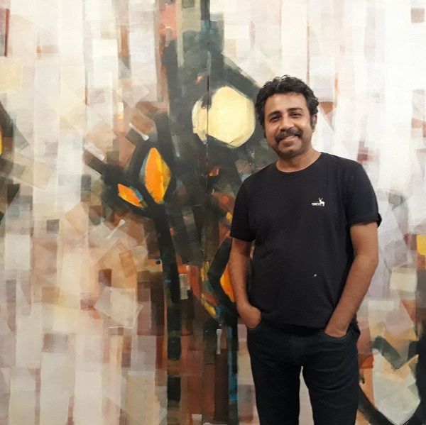 Pankaj Jha con su pintura de fondo