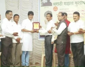   Kiran Mane bergambar dengan Anugerah Gadima Mandeshi oleh Yayasan Aadhar