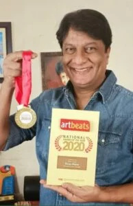   Kiran Mane poseeraa parhaan miespääosan palkinnon kanssa marathi-näytelmästä Jund