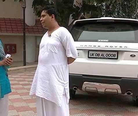 Acharya Balkrishna com seu Range Rover (atrás)