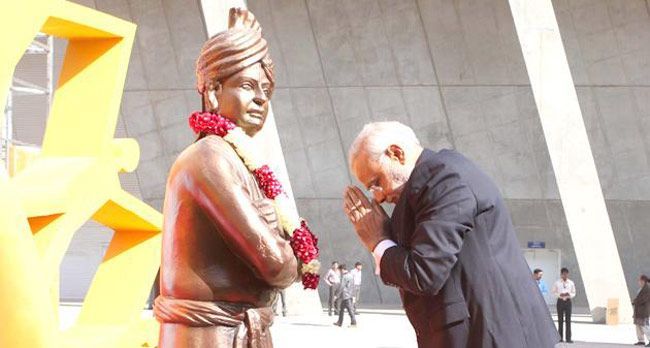 Narendra Modi kumartaa kunnioitusta Vivekanandan patsas edessä