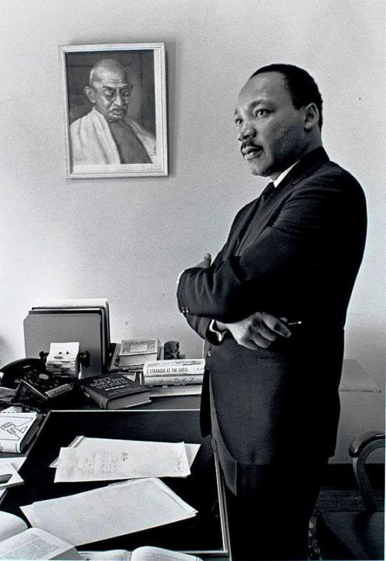   Martin Luther King stojící před portrétem Mahátmy Gándhího
