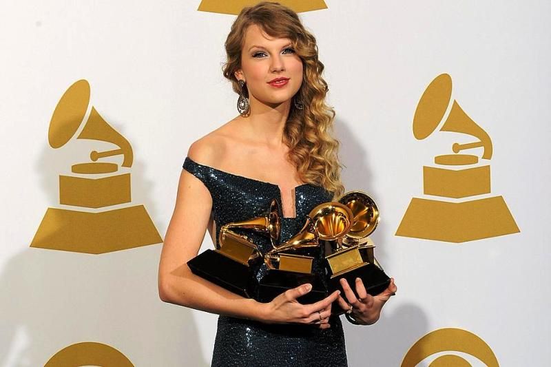 Taylor Swift pozirajući s nagradama Grammy