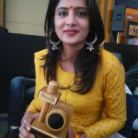 Neha Batham sosteniendo un premio