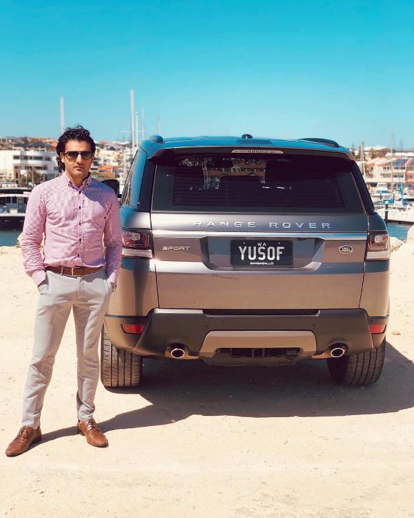 Yusof Mutahar pózol a Range Roverjével