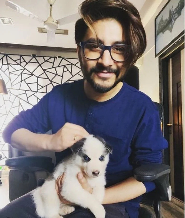   Arjuna Harjai posiert mit einem Hund