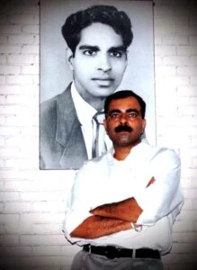   Sanjay Popli posant devant son père's portrait