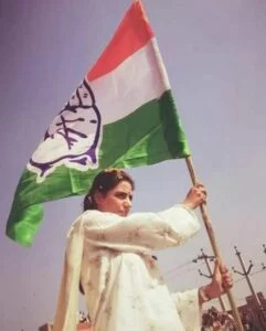   Divya Maderna ținând steagul de partid al Congresului Național Indian