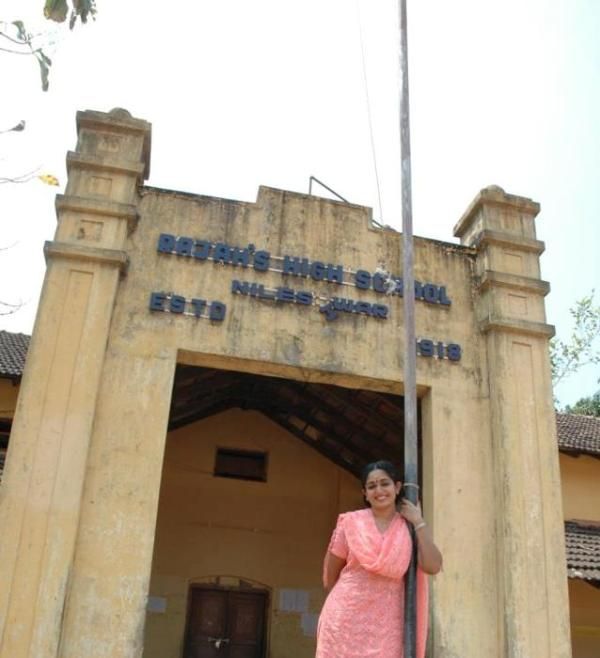 Kavya Madhavan posant devant sa porte d'école