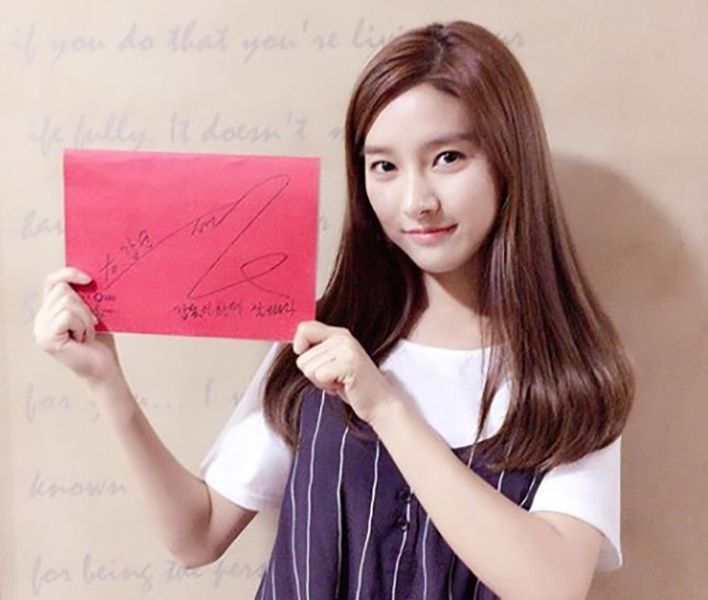Kim So-eun hält ein Plakat mit ihrem Autogramm