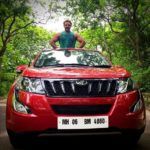 Devdatta Nage pose avec sa voiture Mahindra XUV500